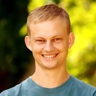 Lachender junger Mann mit blonden Haaren