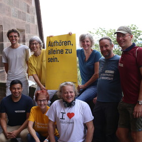 Gruppe von Menschen mit Plakat mit der Aufschrift: Aufhören alleine zu sein.