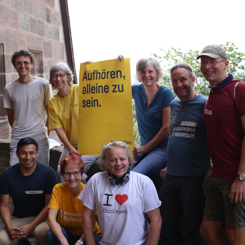 Gruppe von Menschen mit Plakat mit der Aufschrift: Aufhören alleine zu sein.